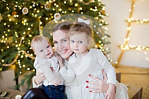 Mother, son, daughter near Christmas tree