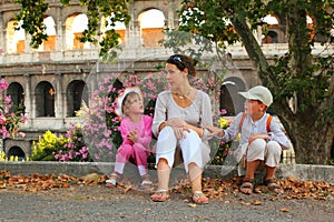 Mother, son and daughter sitting near Colosseum