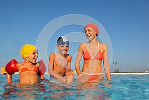 Mother with son and daughter sitting in pool