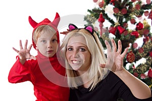 Mother and son in deuce costumes under Christmas tree