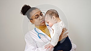 Mother and son doctor holding baby on arms over isolated white background