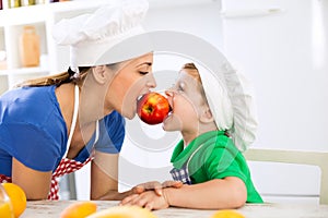 Mother and son eating together red fresh apple