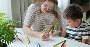 Mother and son engaging in drawing activity at home