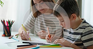 Mother and son engaging in drawing activity at home