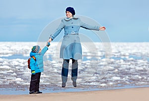 Mother and son enjoying time at winter beach