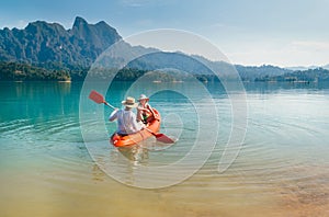 Mother and son floating on kayak together on Cheow Lan lake in Thailand. Traveling with kids concept image