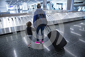 Mother and son going on holiday, wearing face masks at the airport.