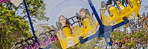 Mother and son having a ride in the bumper car at the amusement park BANNER, LONG FORMAT