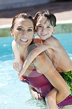 Madre un hijo sobre su espalda en nadar piscina 