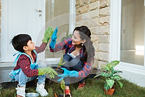 Mother and son highfive while gardening together at home