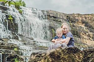Mother and son hikers, tourists on the background of Amazing Pongour Waterfall is famous and most beautiful of fall in Vietnam. N