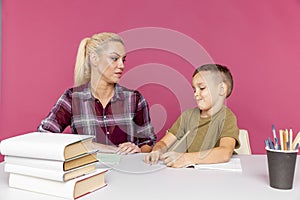 Mother with son at home doing homework together in quarantine time.