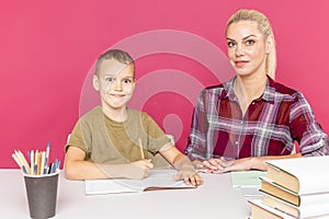 Mother with son at home doing homework together in quarantine time.