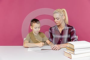 Mother with son at home doing homework together in quarantine time.