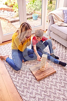 Mother And Son At Home Playing Game Stacking And Balancing Wooden Blocks Together