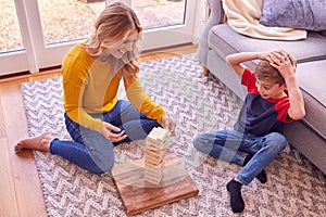 Mother And Son At Home Playing Game Stacking And Balancing Wooden Blocks Together