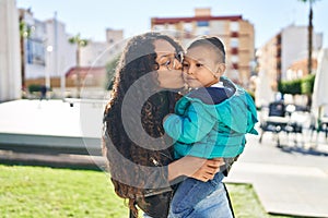 Mother and son hugging each other and kissing at park