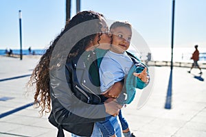 Mother and son hugging each other and kissing at seaside