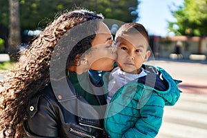 Mother and son hugging each other and kissing at street