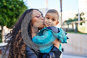 Mother and son hugging each other and kissing at street