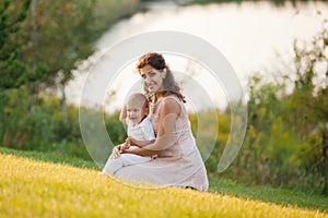 Mother and son hugging and playing near the lake