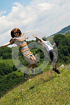 Mother and son jumping in meadow