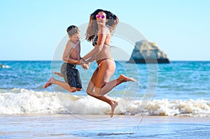 Mother and son jumping in the sea