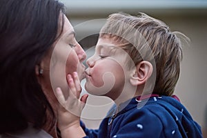 Mother, son and kiss or care with love for bonding, comfort and security with healthy relationship. Family, woman and