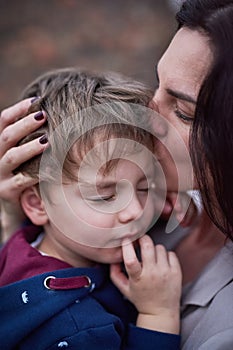 Mother, son and kiss or hug with love for bonding, comfort and security with healthy relationship. Family, woman and boy