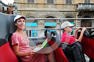 Mother and son looking on street in tour bu