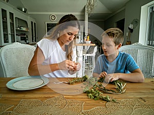 Mother and son make round frame from twigs