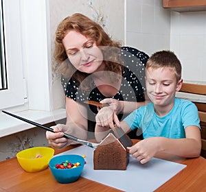 Mother and son making gingerbread house