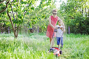 Mother and son mowing grass with lawnmower