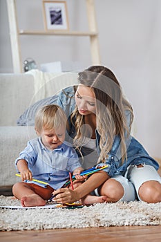 Mother and son paint the walls and floor. Children`s creativity.