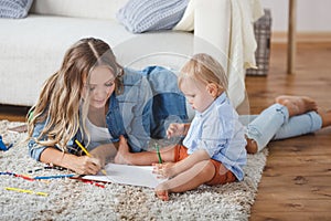 Mother and son paint the walls and floor. Children`s creativity.