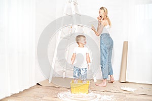 Mother with son painting the wall in home