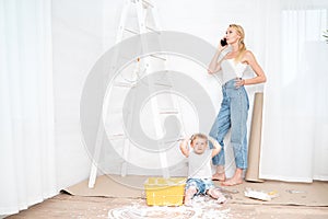 Mother with son painting the wall in home