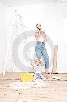 Mother with son painting the wall in home