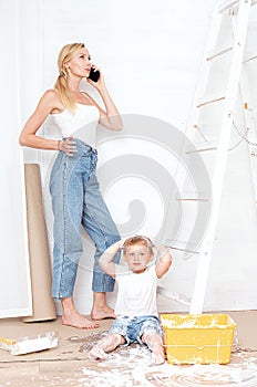 Mother with son painting the wall in home