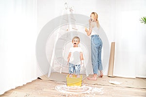 Mother with son painting the wall in home