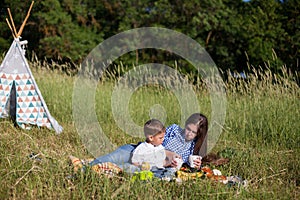 Mother and son at a picnic outdoors eating holiday