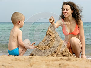 Mother with son play on beach