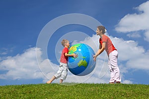 Mother with son play an inflatable globe