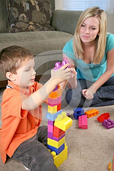 A mother and son playing with blocks