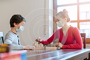 Mother and son playing chess to kill some time during curfew in crises