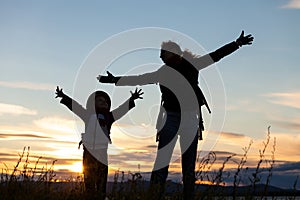 Mother and son playing on the coast of lake of at the sunset ti