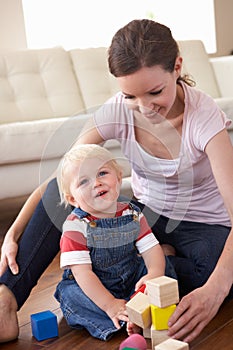 Mother And Son Playing With Coloured Blocks At Hom