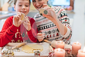 Mother and son playing with cookie cutter in the Christmas kitchen