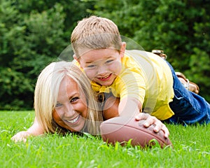 Mother and son playing football outdoors