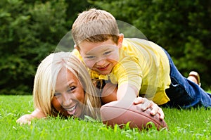 Mother and son playing football outdoors